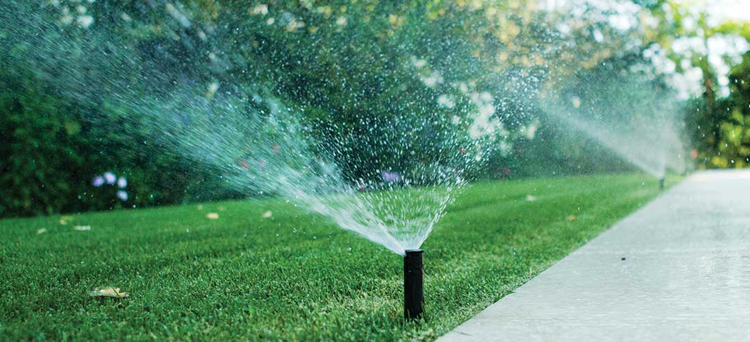 Irrigatore automatico per prato da giardino in azione per irrigare l'erba